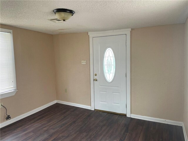 entryway with hardwood / wood-style floors and a textured ceiling