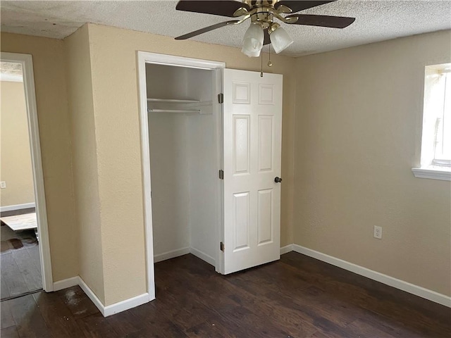 unfurnished bedroom featuring a closet, dark hardwood / wood-style floors, a textured ceiling, and ceiling fan