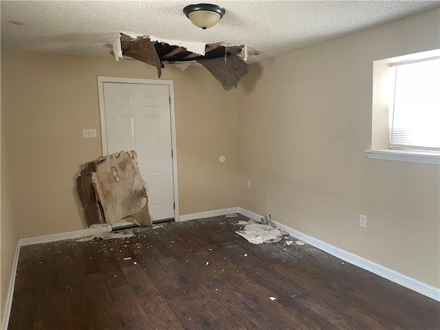 empty room featuring hardwood / wood-style flooring and a textured ceiling