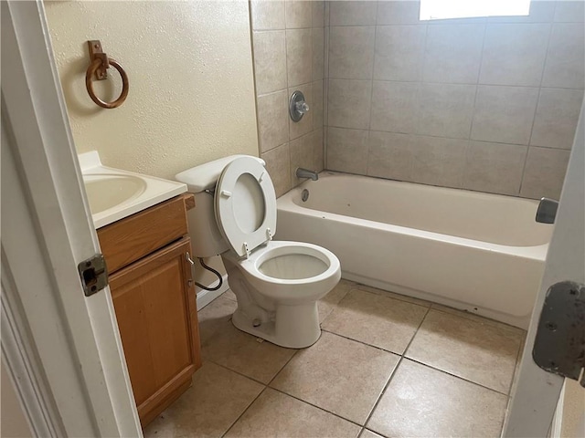 full bathroom with tile floors, tiled shower / bath combo, vanity, and toilet