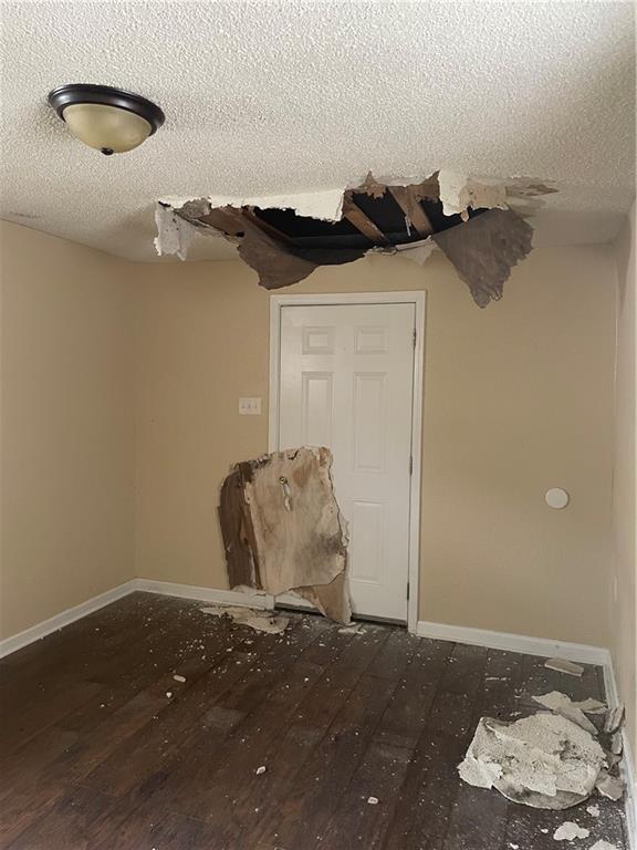 spare room featuring a textured ceiling and hardwood / wood-style floors