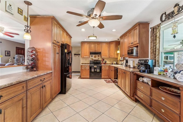 kitchen with under cabinet range hood, light tile patterned floors, brown cabinetry, black appliances, and a ceiling fan