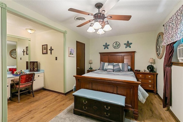 bedroom with light wood-type flooring, visible vents, baseboards, and a ceiling fan