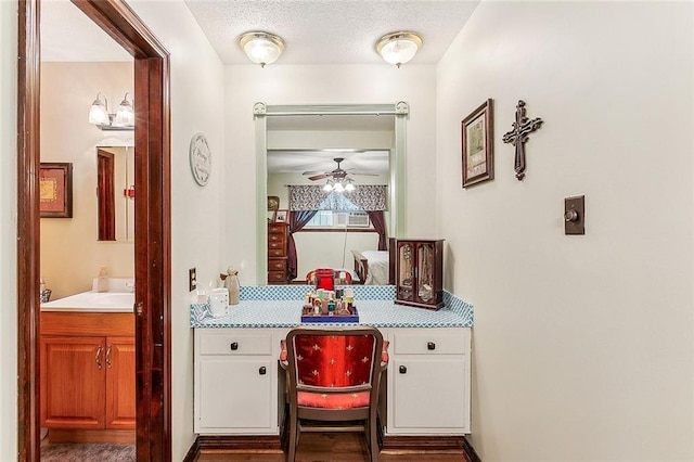 ensuite bathroom featuring ceiling fan, a textured ceiling, vanity, and connected bathroom