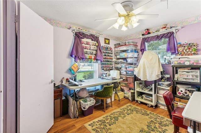 home office with wood finished floors and a ceiling fan