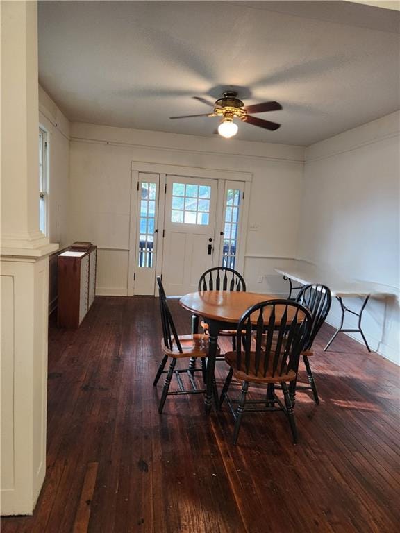 dining space with wood-type flooring, ornate columns, and ceiling fan