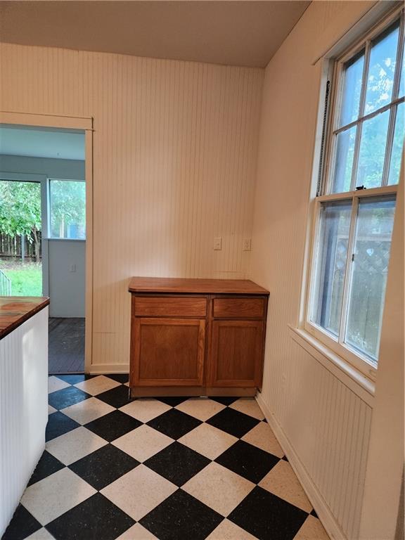 unfurnished dining area featuring baseboards and light floors