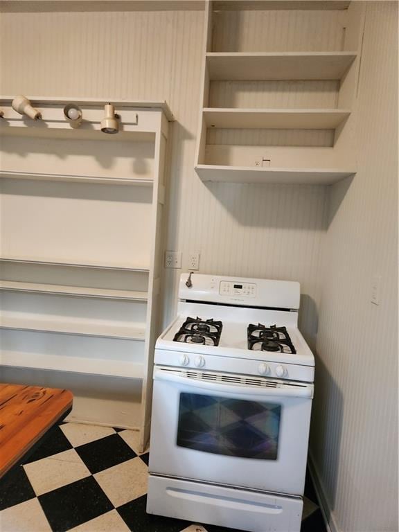 kitchen featuring tile patterned floors, gas range gas stove, and open shelves