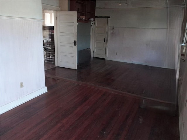 empty room featuring baseboards and wood finished floors