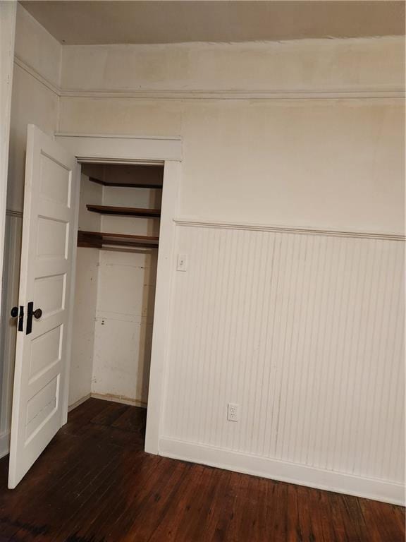 unfurnished bedroom featuring wood-type flooring and a closet