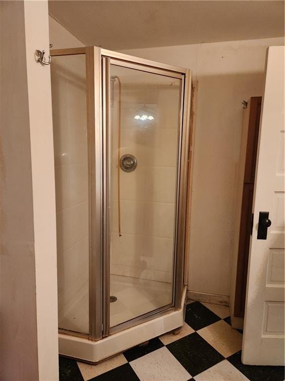 bathroom with a shower with door and tile patterned flooring