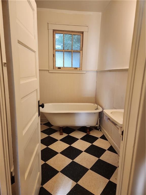 bathroom with tile patterned floors and a bath