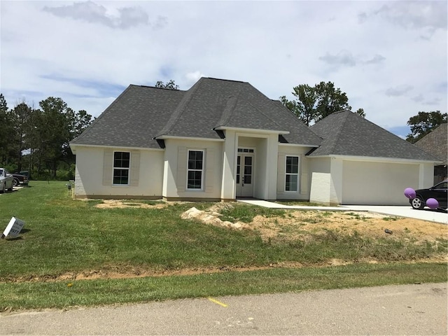 view of front facade with a garage and a front lawn