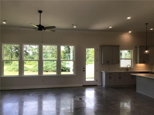 kitchen featuring ceiling fan, pendant lighting, sink, and dark tile patterned flooring