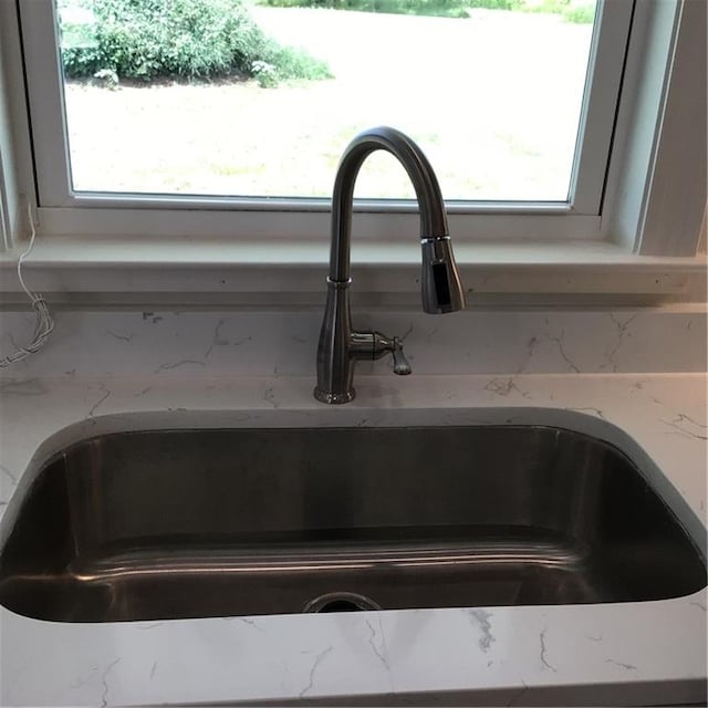 room details featuring sink and light stone countertops