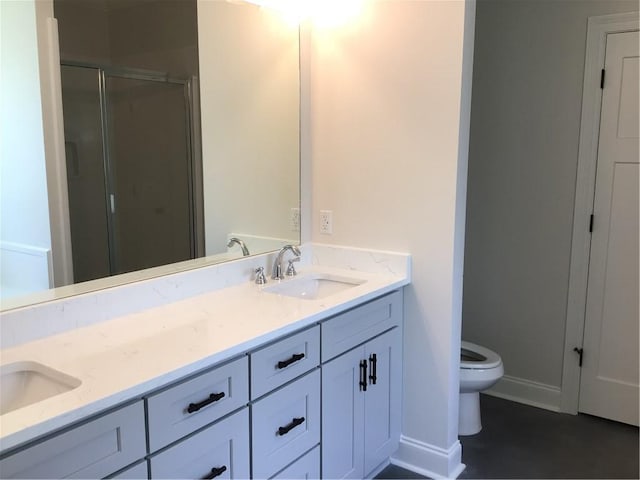 bathroom featuring a shower with door, toilet, and vanity