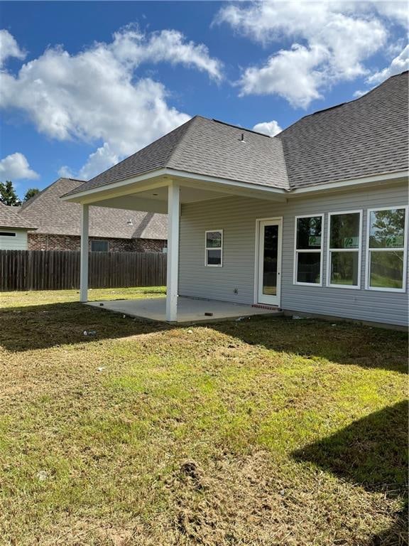 rear view of property with a patio and a lawn