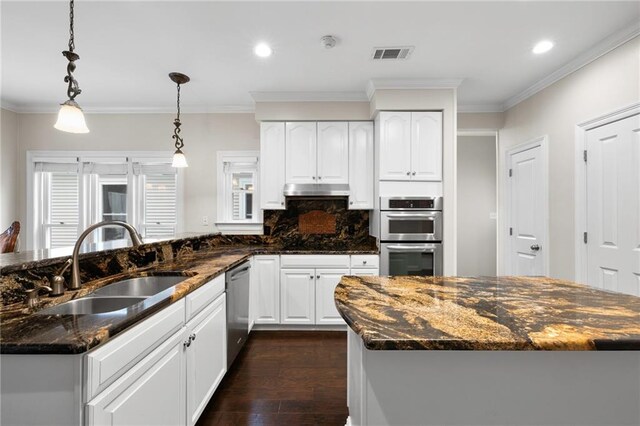 kitchen featuring dark stone counters, sink, dark wood-type flooring, and appliances with stainless steel finishes