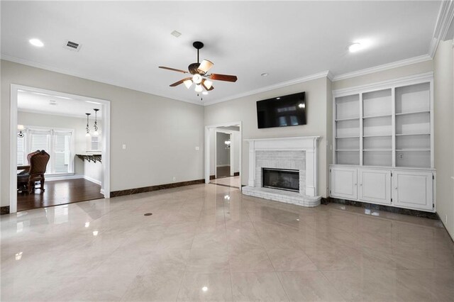 unfurnished living room with crown molding, a fireplace, tile floors, built in features, and ceiling fan