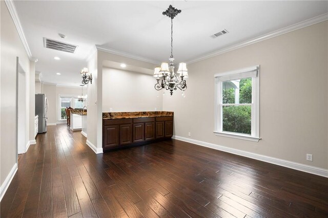 kitchen with dark hardwood / wood-style floors, crown molding, hanging light fixtures, stainless steel refrigerator, and a chandelier