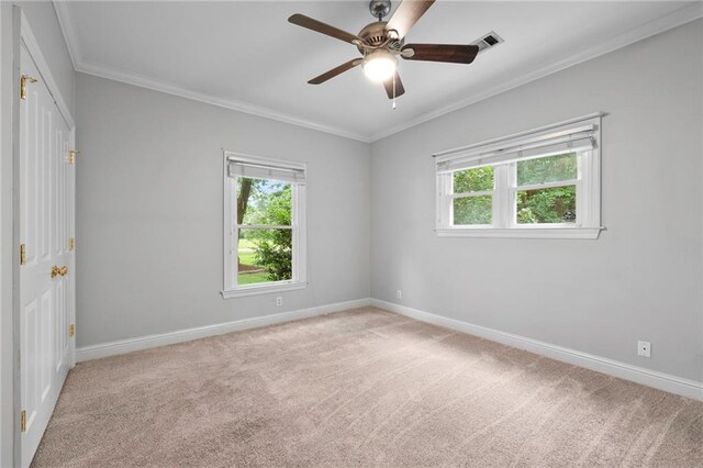 carpeted empty room featuring ceiling fan and crown molding