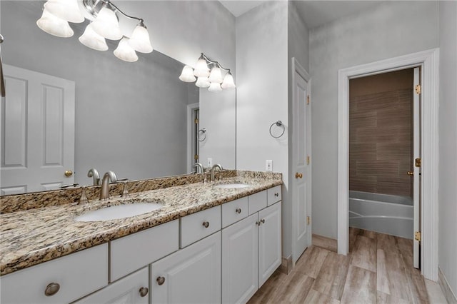 bathroom featuring dual bowl vanity, shower / bathing tub combination, and hardwood / wood-style floors