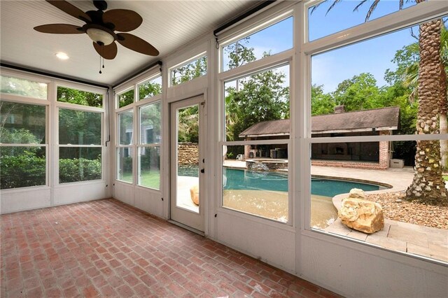 unfurnished sunroom featuring ceiling fan