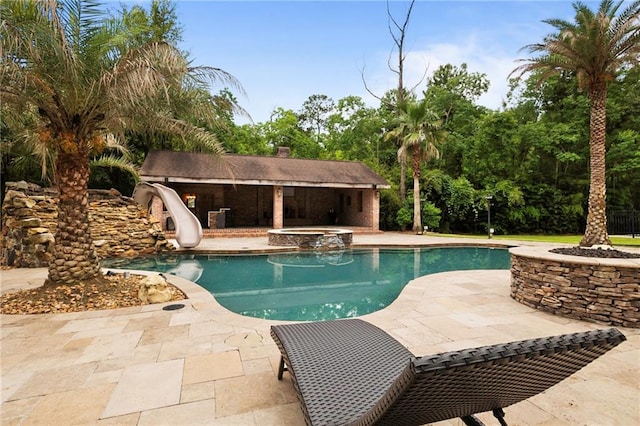 view of pool with a water slide and a patio