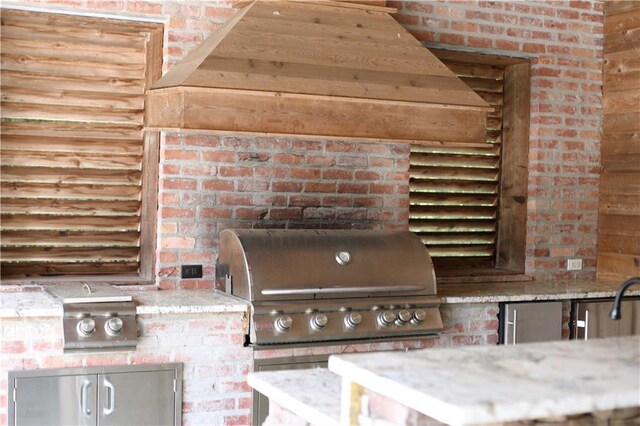 kitchen with brick wall and light stone countertops