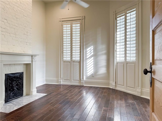 unfurnished living room featuring ceiling fan and dark hardwood / wood-style flooring