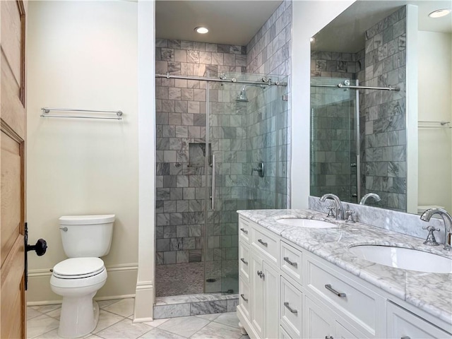 bathroom with vanity, toilet, and a shower with door