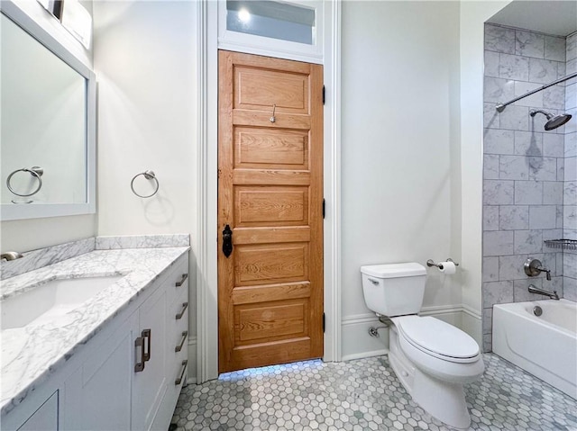 full bathroom with tile patterned floors, tiled shower / bath, vanity, and toilet