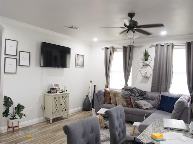 living room featuring crown molding, plenty of natural light, ceiling fan, and light hardwood / wood-style flooring