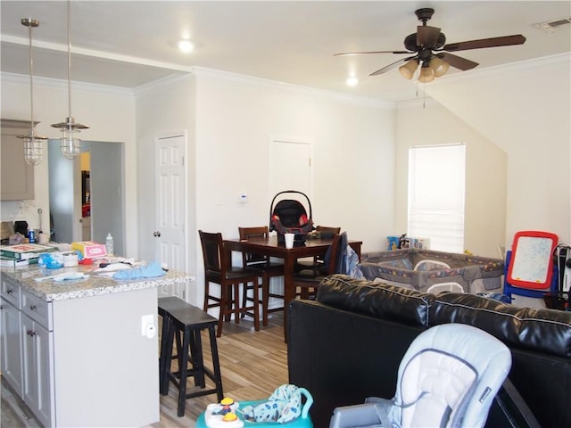 living room featuring ceiling fan, light wood-type flooring, and crown molding