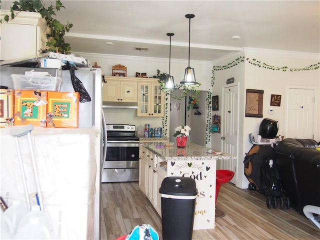 kitchen featuring fridge, electric stove, light wood-type flooring, pendant lighting, and light stone counters