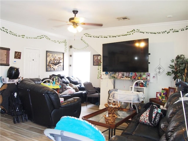 living room featuring hardwood / wood-style floors, ornamental molding, and ceiling fan