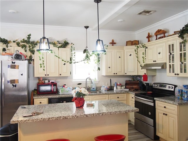 kitchen featuring hardwood / wood-style floors, cream cabinets, stainless steel appliances, decorative light fixtures, and sink