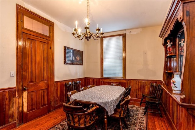 4102 Dauphine St, New Orleans, LA 70117 - dining space featuring a chandelier, wainscoting, hardwood / wood-style flooring, and wood walls