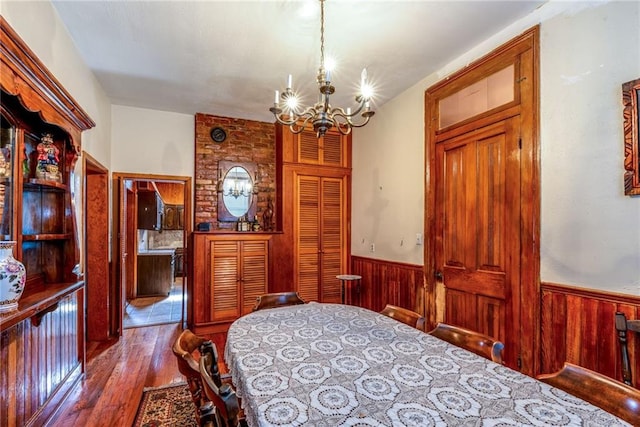 4102 Dauphine St, New Orleans, LA 70117 - bedroom with a chandelier, wainscoting, hardwood / wood-style floors, and wood walls