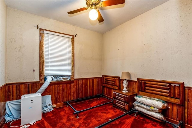 4102 Dauphine St, New Orleans, LA 70117 - bedroom with wood walls, a wainscoted wall, carpet, and ceiling fan
