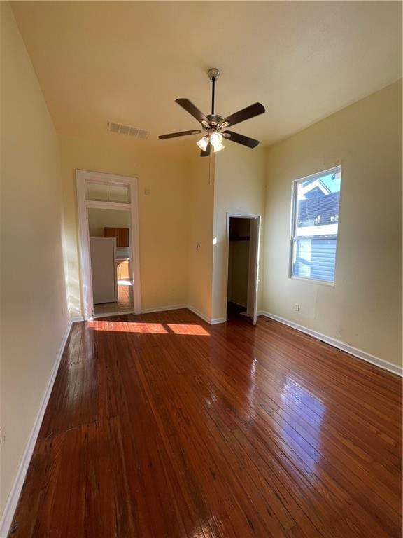 empty room featuring ceiling fan and dark wood-type flooring