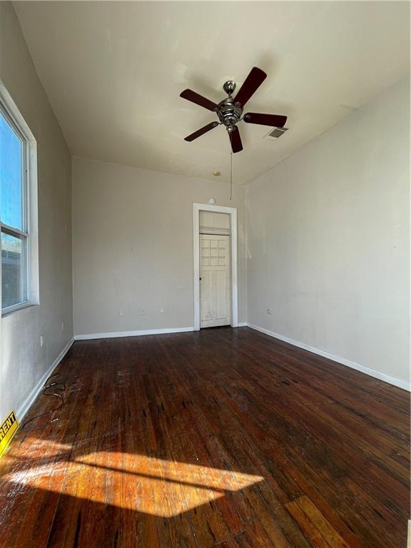 unfurnished room featuring ceiling fan and dark wood-type flooring