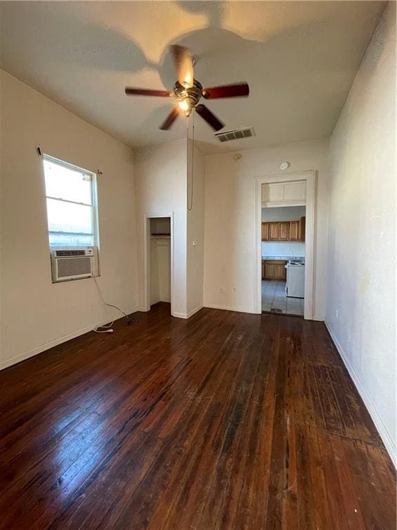 empty room with ceiling fan, cooling unit, and dark hardwood / wood-style flooring