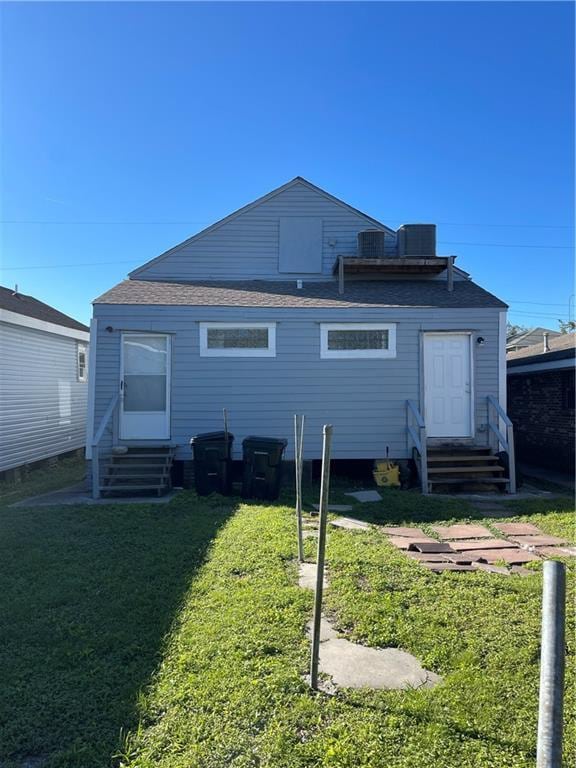 rear view of house featuring a yard and cooling unit