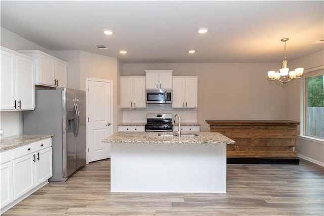 kitchen featuring sink, an island with sink, hanging light fixtures, and appliances with stainless steel finishes