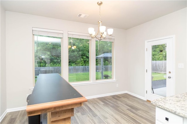 dining space with an inviting chandelier and light hardwood / wood-style flooring