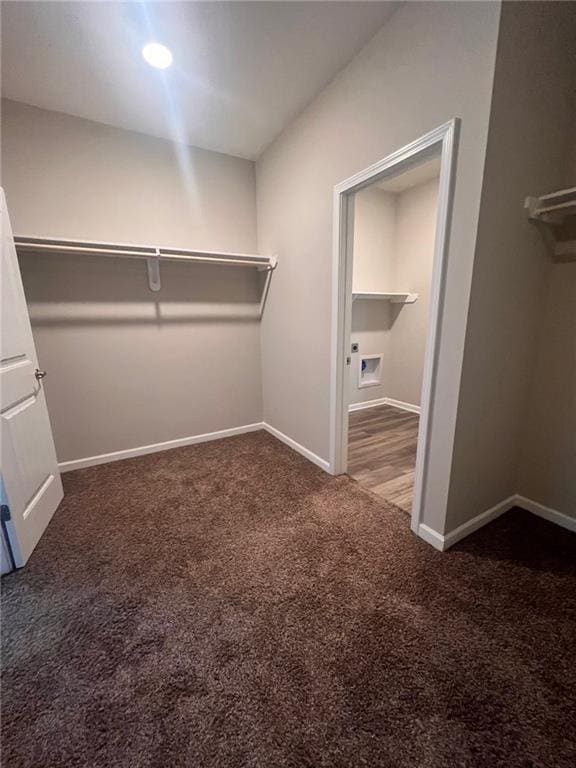 walk in closet featuring dark colored carpet