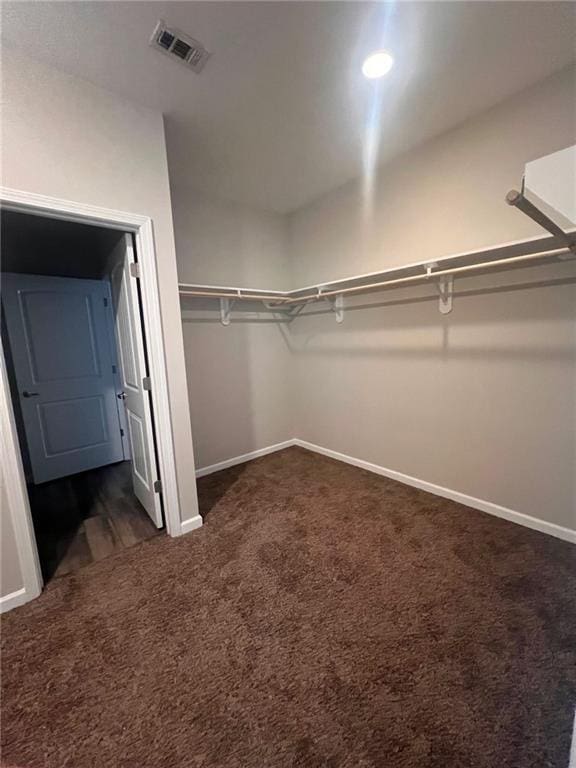 spacious closet featuring dark carpet