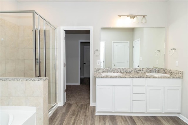 bathroom featuring shower with separate bathtub, vanity, and wood-type flooring