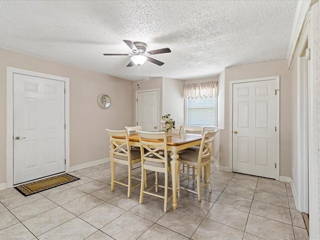 tiled dining room featuring ceiling fan and a textured ceiling